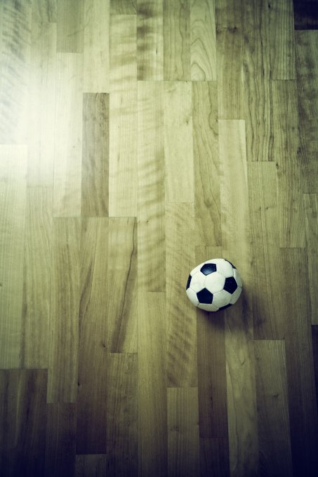 piłka nożna leżąca na drewnianych panelach